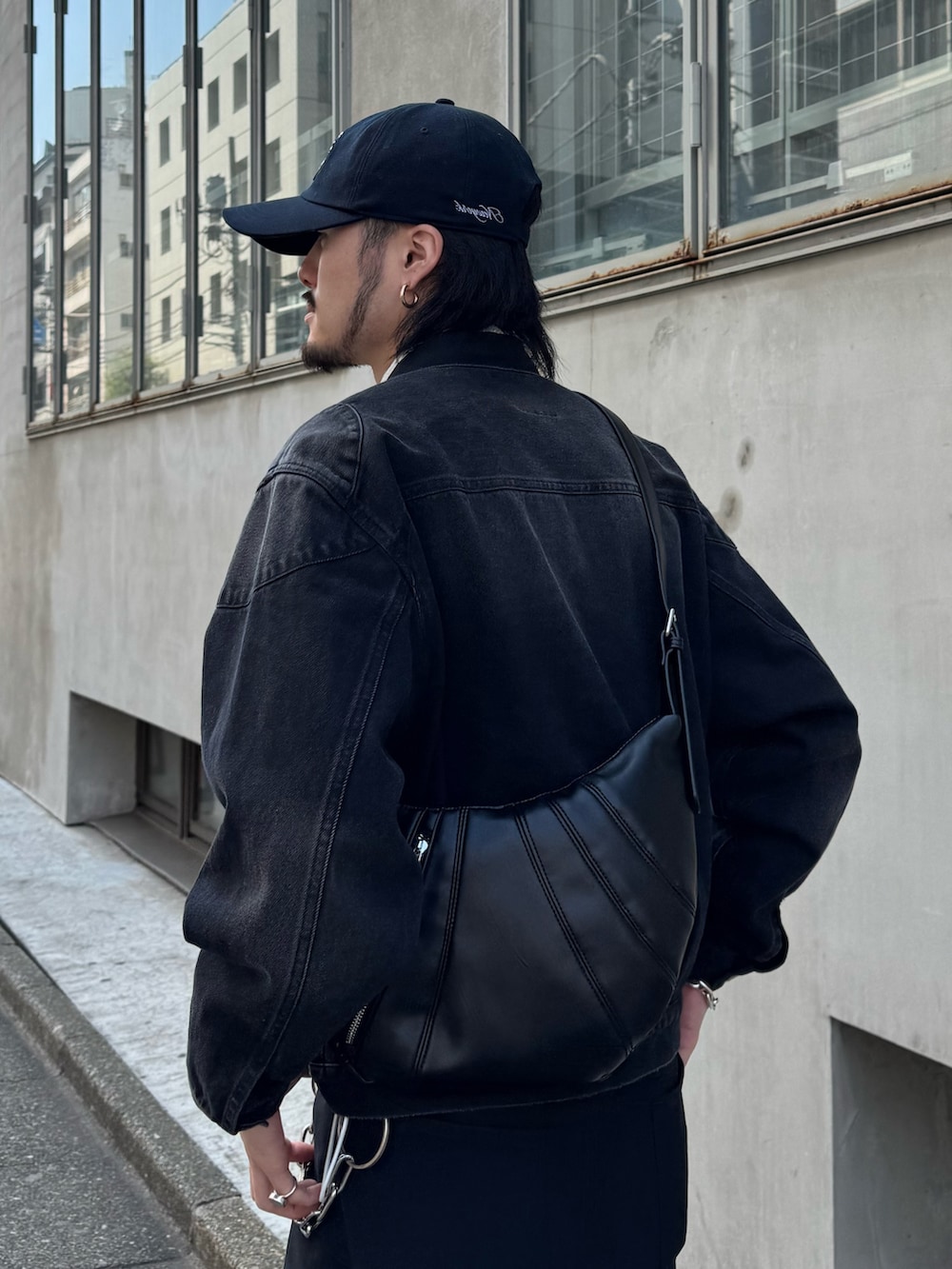 ブラック系のスラックス、ブラック系のショルダーバッグ、ホワイト系のシャツ/ブラウスを着用したメンズの春コーディネートの4枚目の写真