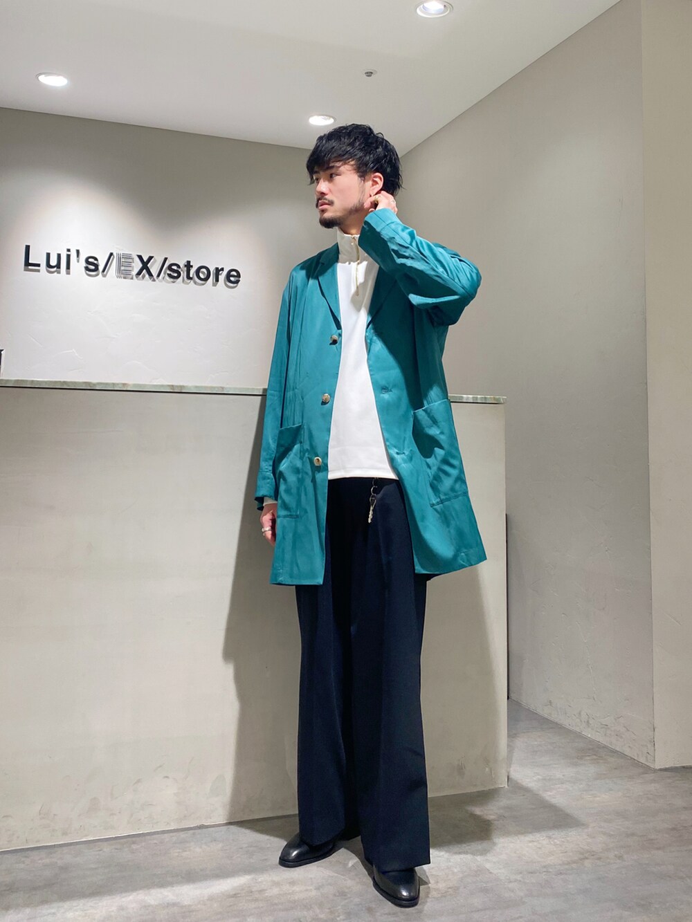 ブラック系のスラックス、ブラック系のドレスシューズ、ホワイト系のTシャツ/カットソーを着用したメンズの春コーディネートの2枚目の写真