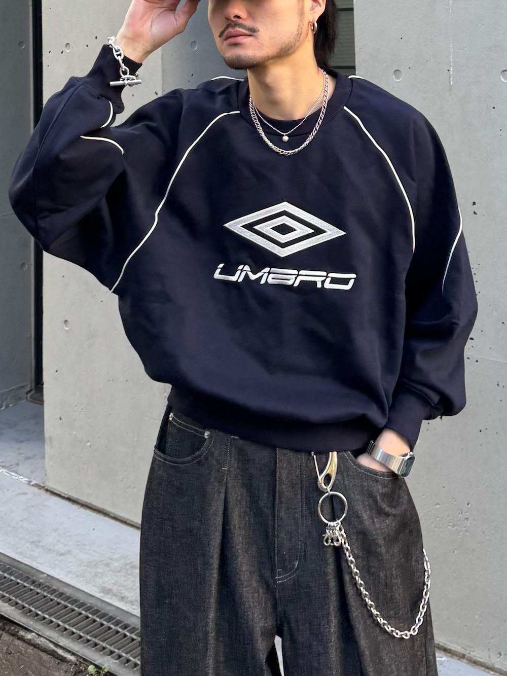 ブルー系のスウェット、ブラック系のデニムパンツを着用したメンズの冬コーディネートの7枚目の写真