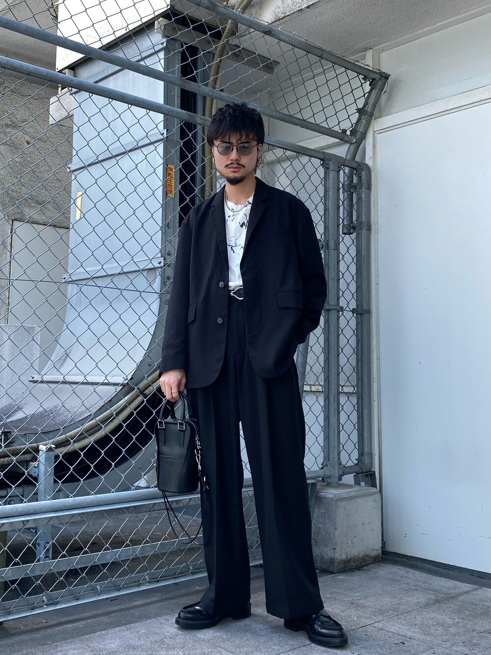 ブラック系のテーラードジャケット、ブラック系のその他パンツ、ホワイト系のTシャツ/カットソーを着用したメンズの秋コーディネートの2枚目の写真