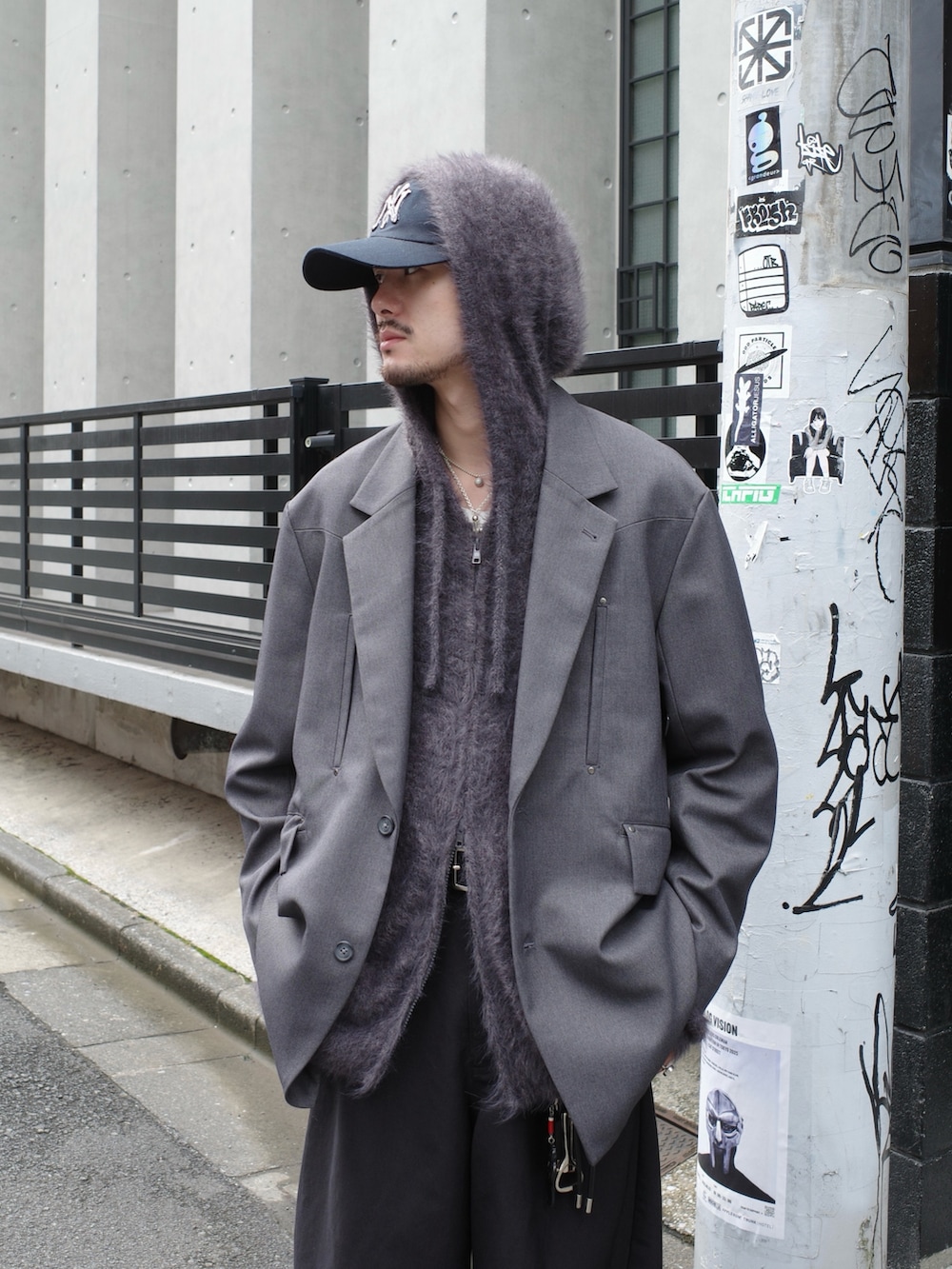 グレー系のテーラードジャケット、ブラック系のスラックス、グレー系のニット/セーターを着用したメンズの秋コーディネートの4枚目の写真