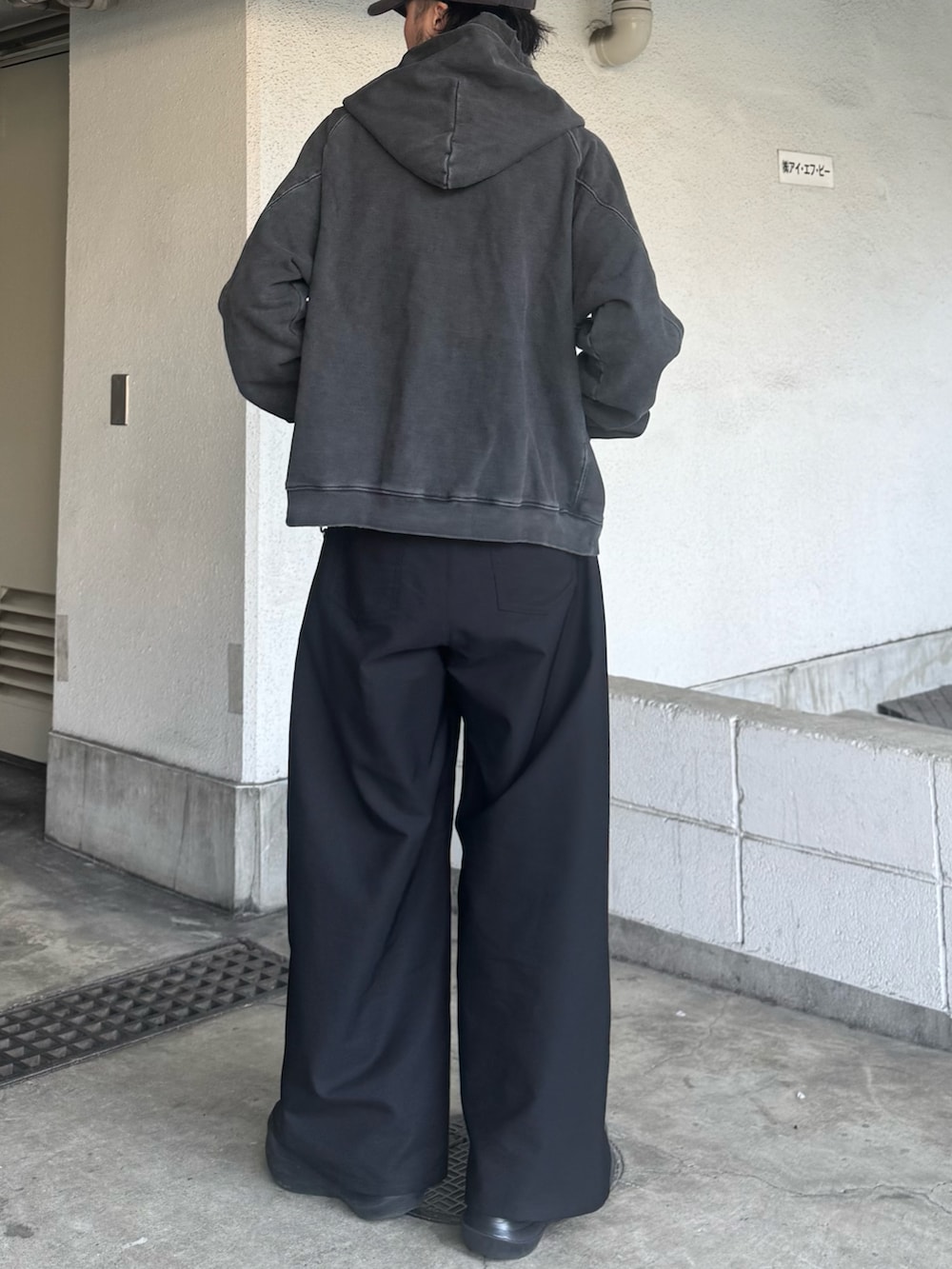 ブラック系のパーカー、ブラック系のスラックスを着用したメンズの春コーディネートの3枚目の写真