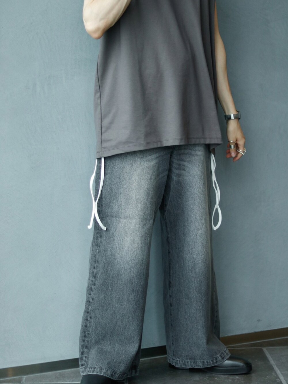 グレー系のTシャツ/カットソー、ホワイト系のタンクトップ、ブラック系のデニムパンツを着用したメンズの夏コーディネートの4枚目の写真