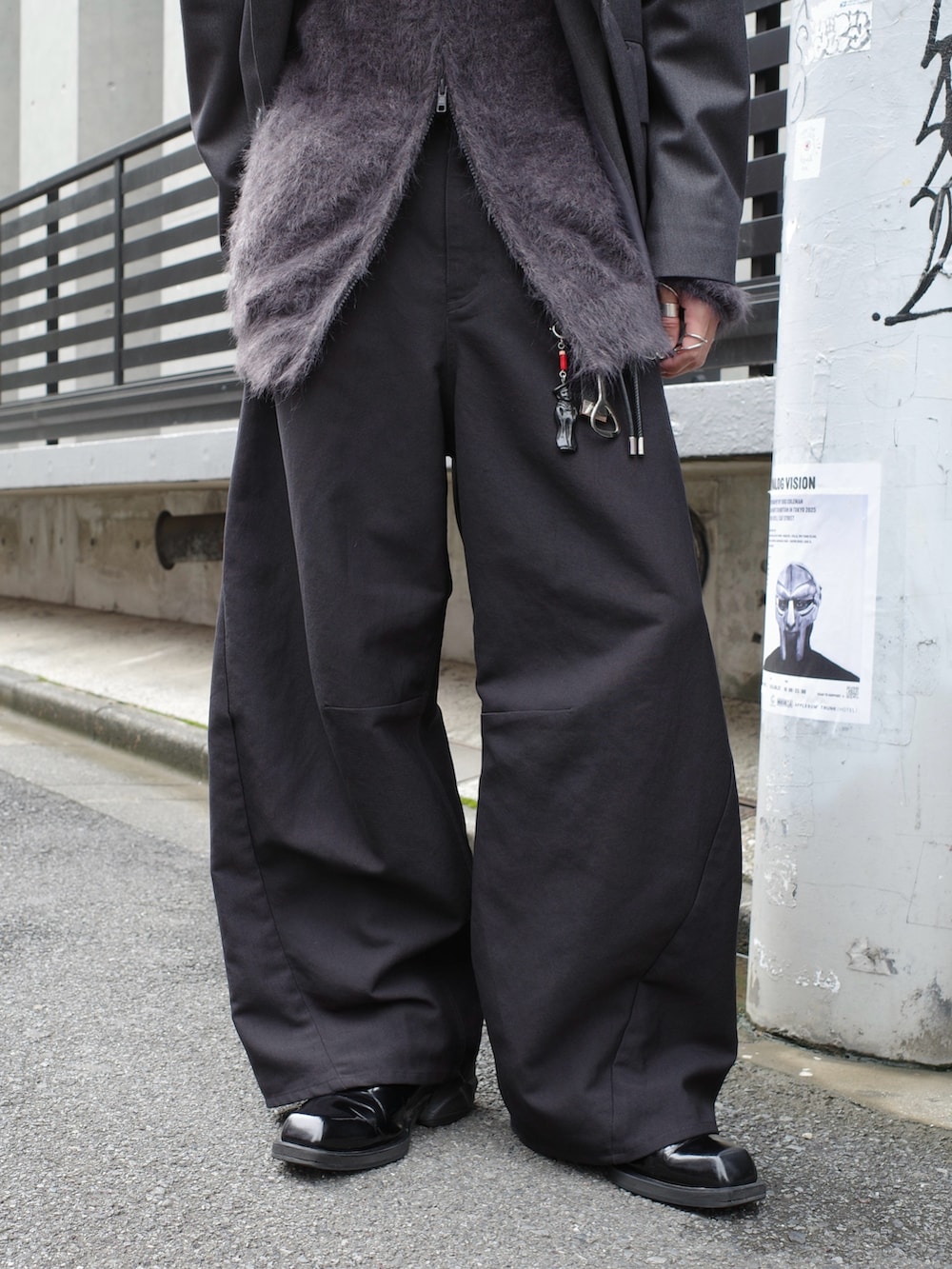 グレー系のテーラードジャケット、ブラック系のスラックス、グレー系のニット/セーターを着用したメンズの秋コーディネートの7枚目の写真