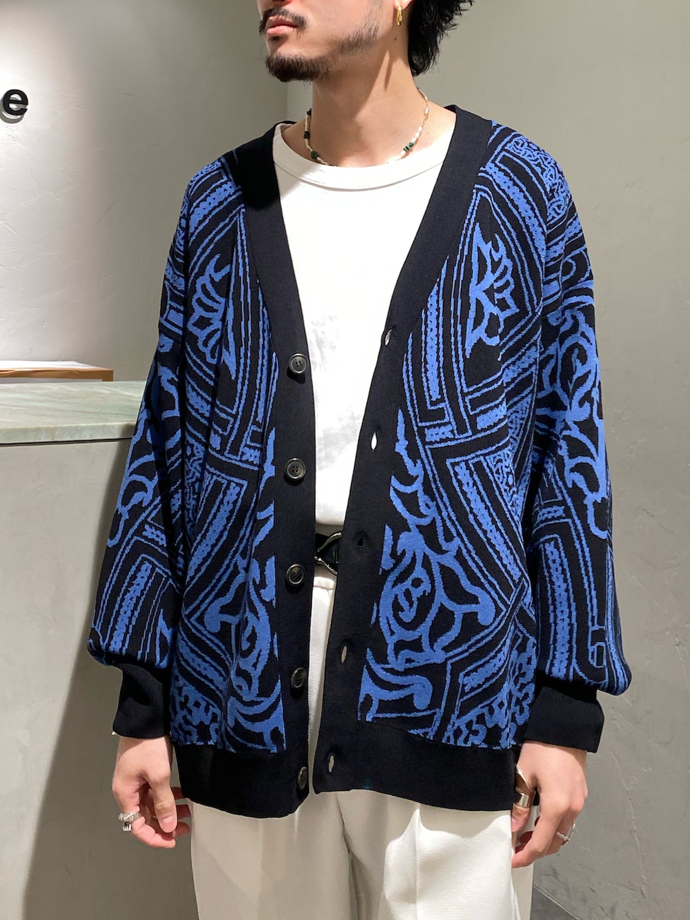 ブラック系のカーディガン/ボレロ、ホワイト系のスラックスを着用したメンズの春コーディネートの4枚目の写真