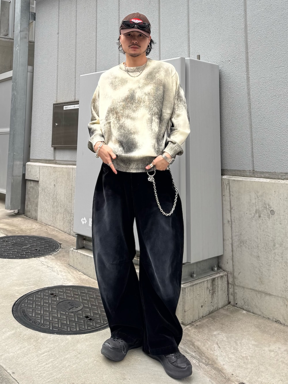 ホワイト系のニット/セーター、ブラック系のデニムパンツ、シルバー系のウォレットチェーンを着用したメンズの春コーディネートの2枚目の写真