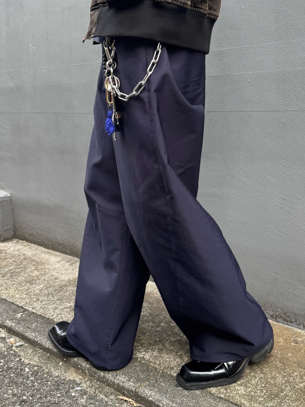 ブラウン系のデニムジャケット、ブルー系のスラックス、ブルー系のキャップを着用したメンズの秋コーディネートの7枚目の写真