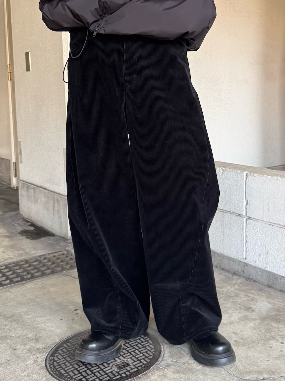 ブラック系のダウンジャケット/コート、ブラック系のブーツ、ブラック系のその他パンツを着用したメンズの冬コーディネートの7枚目の写真