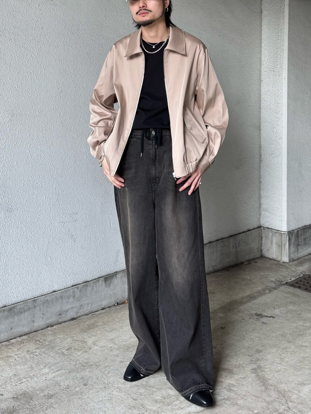 ブラック系のTシャツ/カットソー、ベージュ系のブルゾン、ブラック系のデニムパンツを着用したメンズの春コーディネートの2枚目の写真
