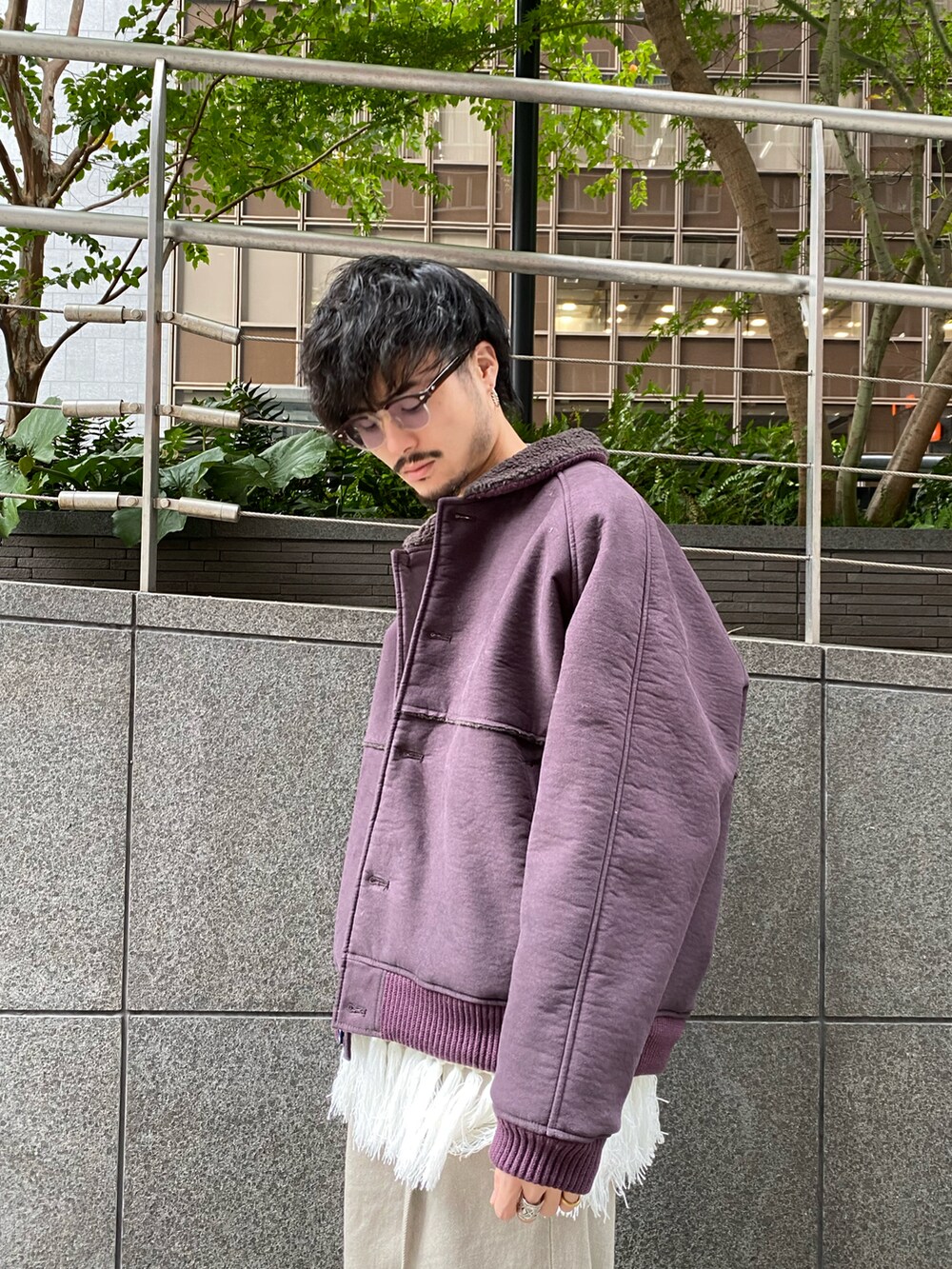 パープル系のブルゾン、ホワイト系のニット/セーター、ベージュ系のデニムパンツを着用したメンズの秋コーディネートの3枚目の写真