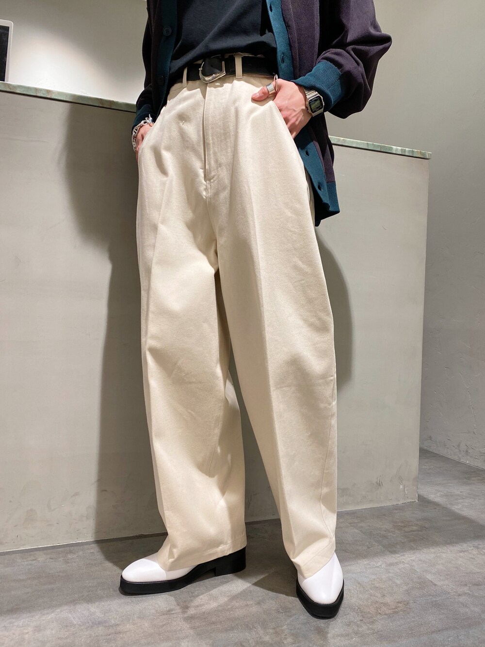 グレー系のカーディガン/ボレロ、ホワイト系のデニムパンツ、ホワイト系のブーツを着用したメンズの春コーディネートの5枚目の写真