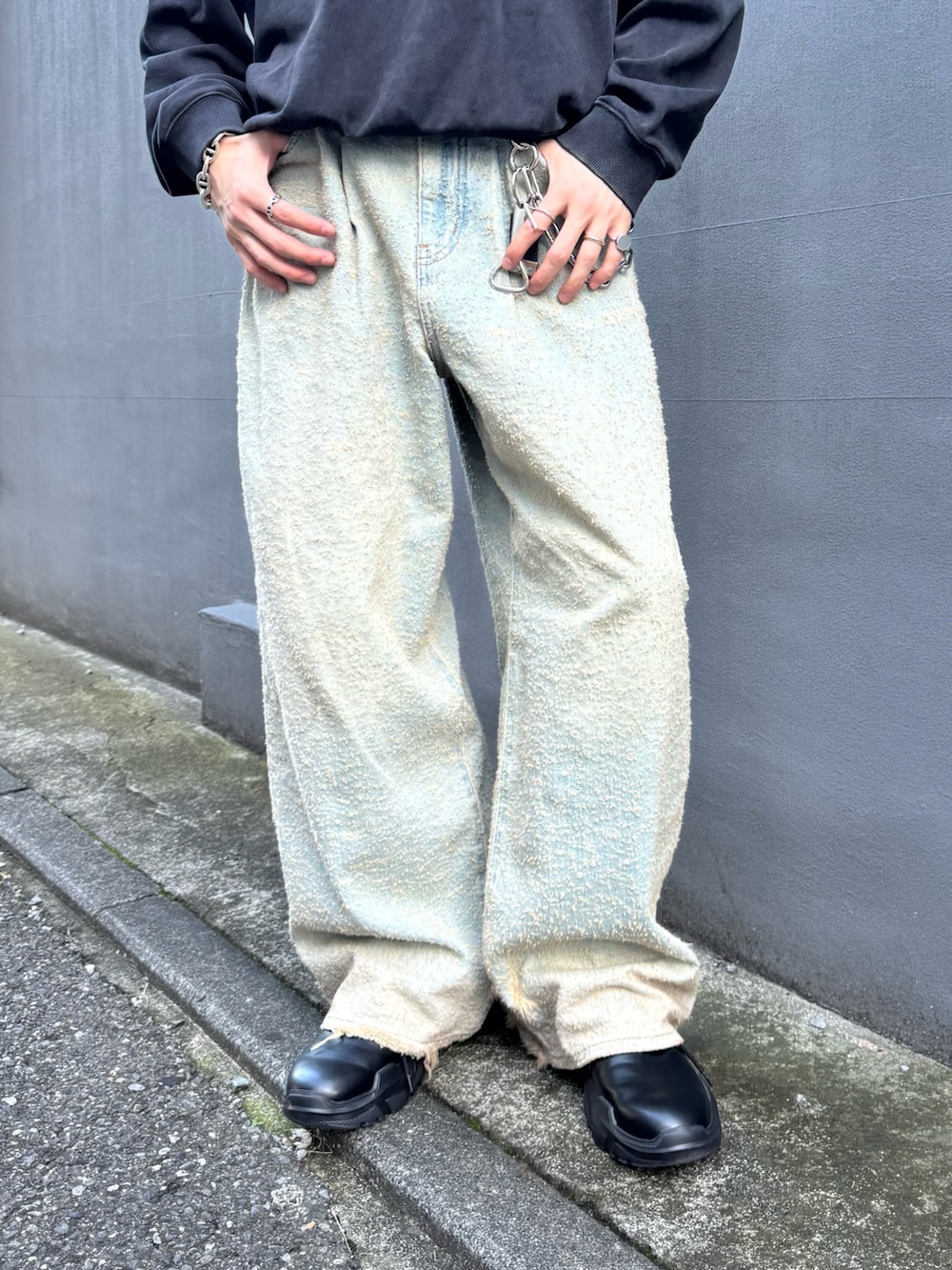 ブラック系のスウェット、ブラック系のその他シューズ、ブルー系のデニムパンツを着用したメンズの秋コーディネートの5枚目の写真