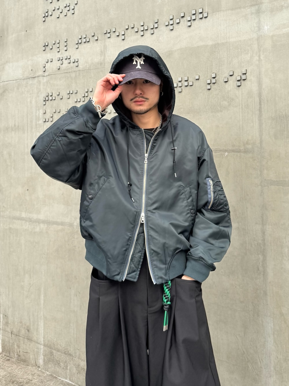 グリーン系のブルゾン、ブラック系のその他パンツ、ブラック系のキーホルダーを着用したメンズの冬コーディネートの5枚目の写真