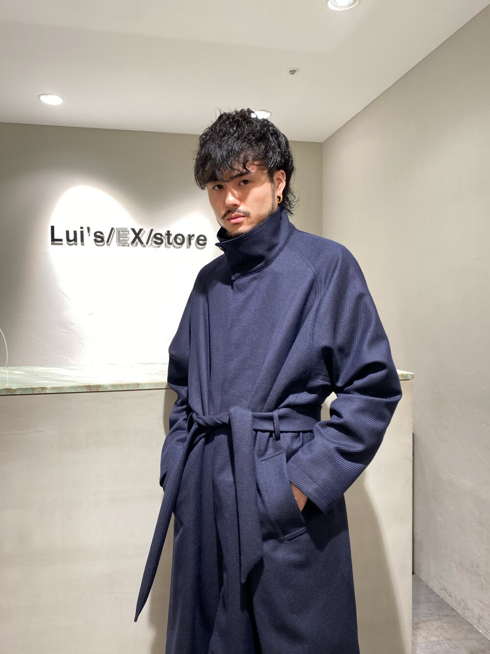 ブルー系のチェスターコート、ブラック系のその他パンツ、ブラック系のドレスシューズを着用したメンズの秋コーディネートの3枚目の写真