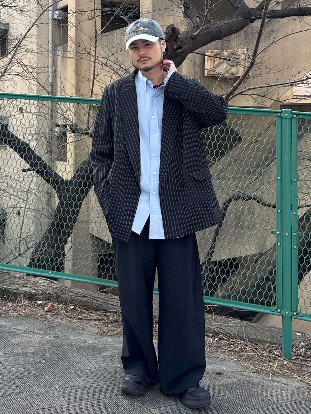 ブラック系のスラックス、ブルー系のシャツ/ブラウス、ブラック系のテーラードジャケットを着用したメンズの春コーディネートの2枚目の写真