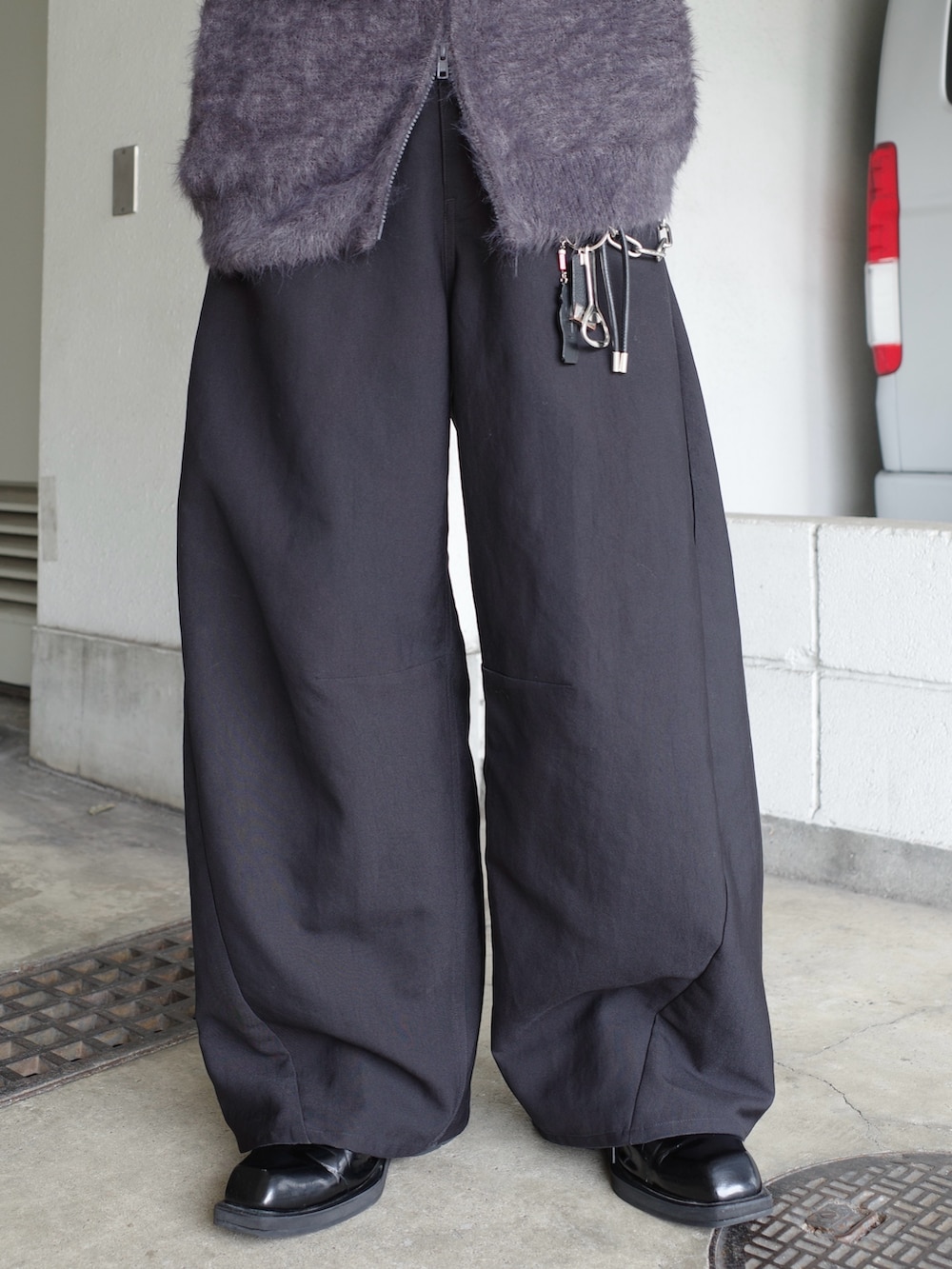 ブラック系のスラックス、グレー系のニット/セーターを着用したメンズの冬コーディネートの5枚目の写真