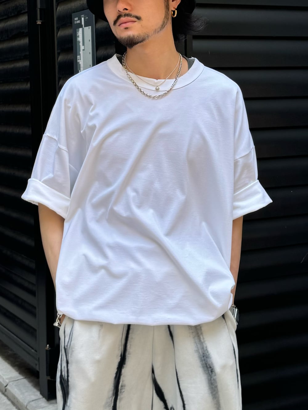 ホワイト系のTシャツ/カットソー、ホワイト系のスウェットパンツ、ブラック系のキャップを着用したメンズの夏コーディネートの3枚目の写真