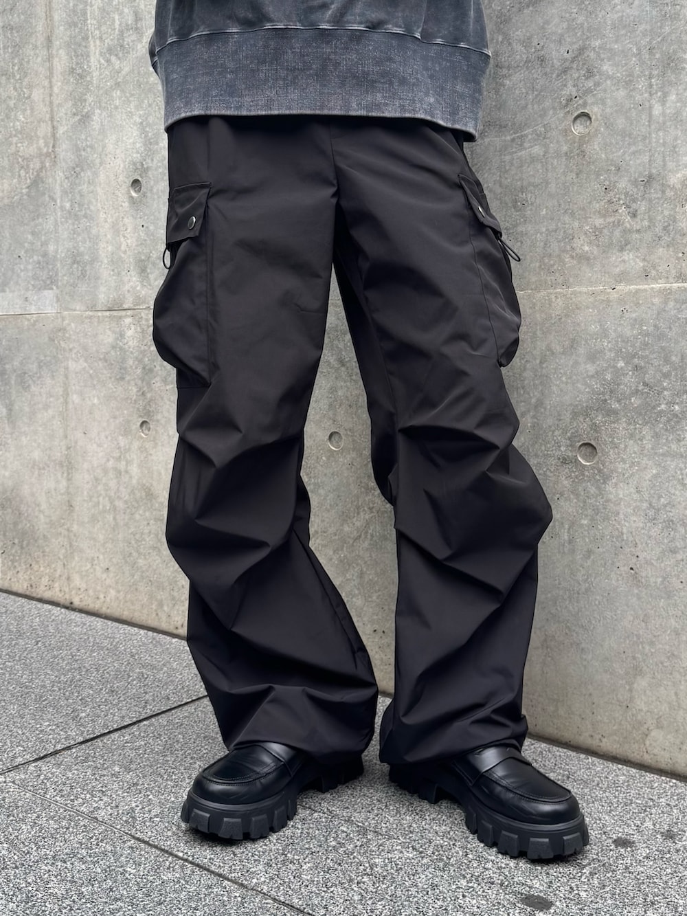 グレー系のスウェット、ブラック系のカーゴパンツを着用したメンズの秋コーディネートの6枚目の写真