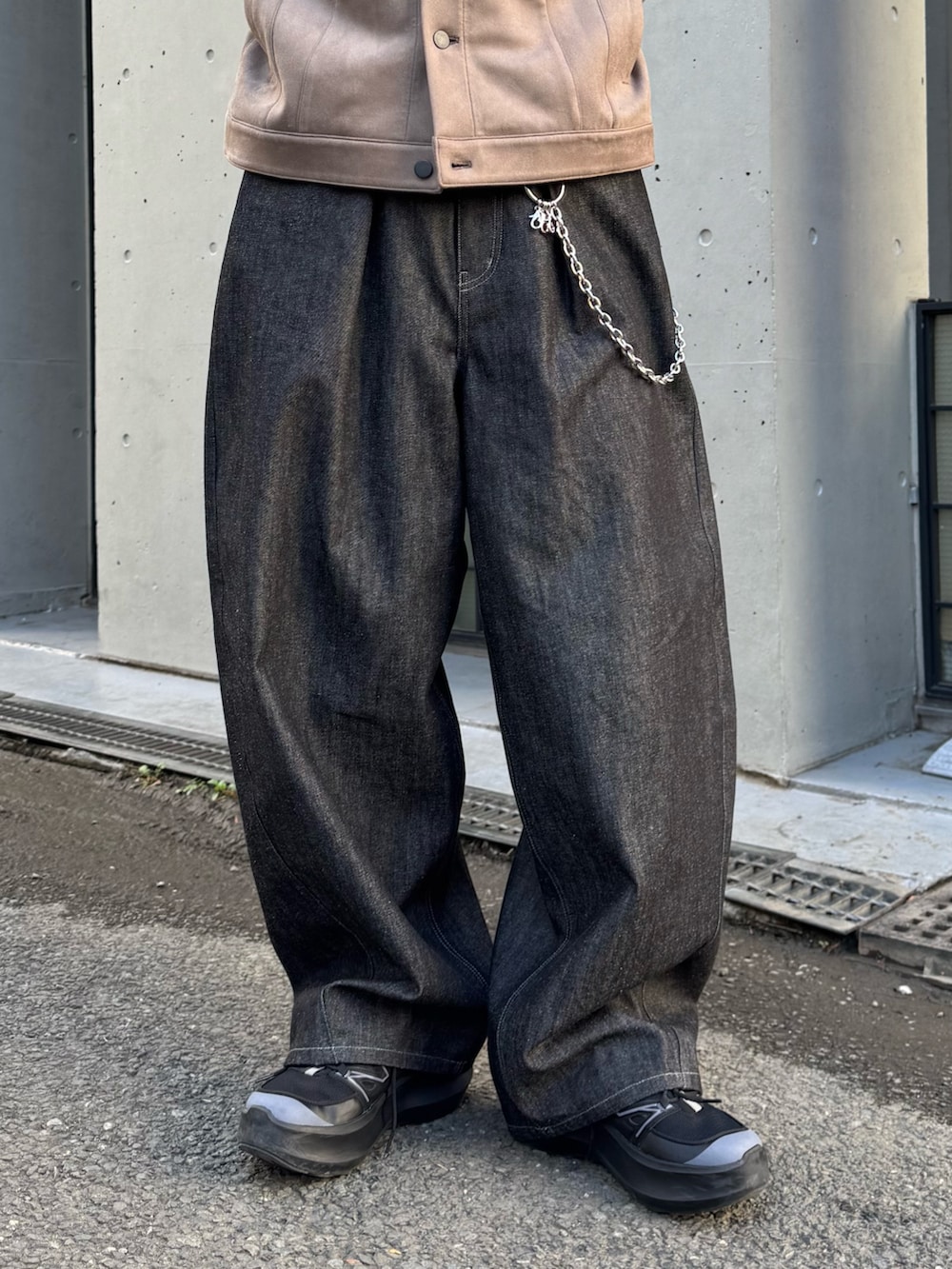 グレー系のブルゾン、ブルー系のニット/セーター、ブラック系のデニムパンツを着用したメンズの冬コーディネートの7枚目の写真