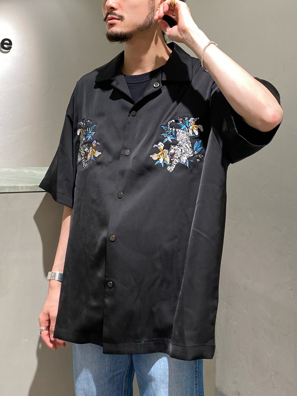 ブラック系のシャツ/ブラウス、ブルー系のデニムパンツ、シルバー系のバングル/リストバンドを着用したメンズの春コーディネートの3枚目の写真