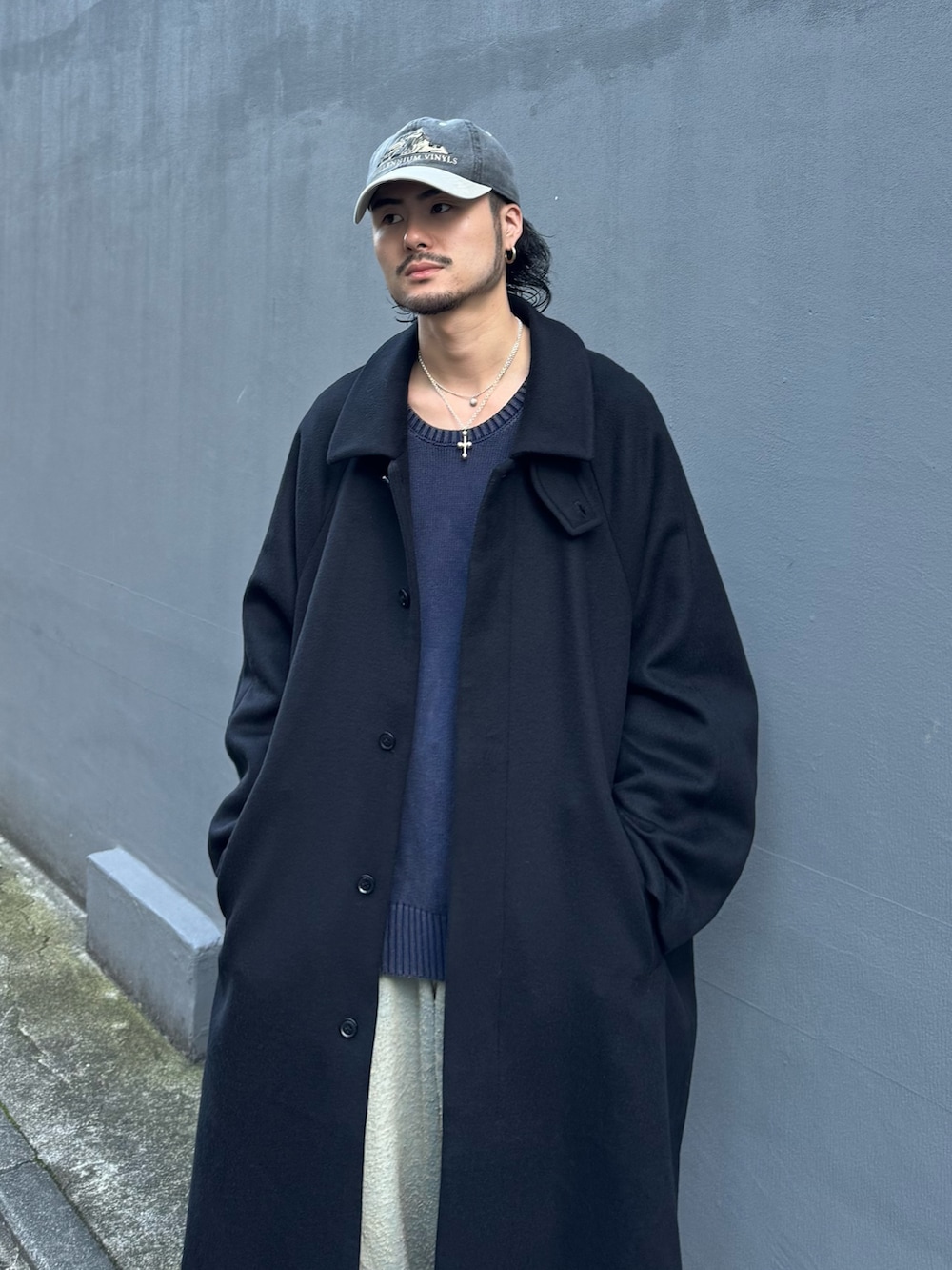 ブルー系のニット/セーター、ブルー系のデニムパンツ、ブラック系のステンカラーコートを着用したメンズの秋コーディネートの8枚目の写真