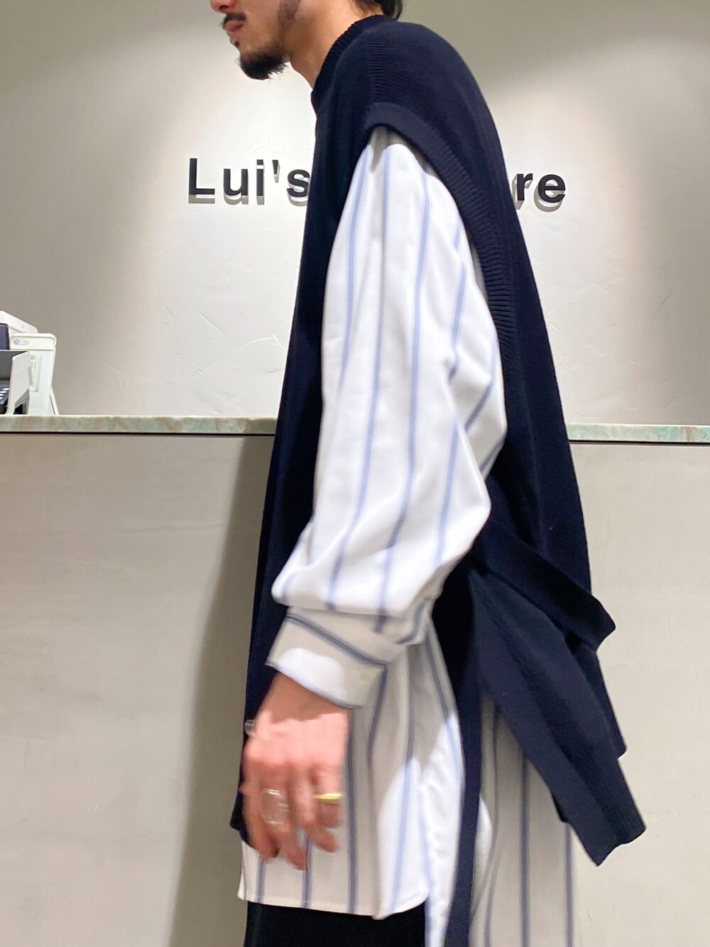 ブラック系のベスト、ホワイト系のシャツ/ブラウス、ブラック系のスラックスを着用したメンズの春コーディネートの5枚目の写真