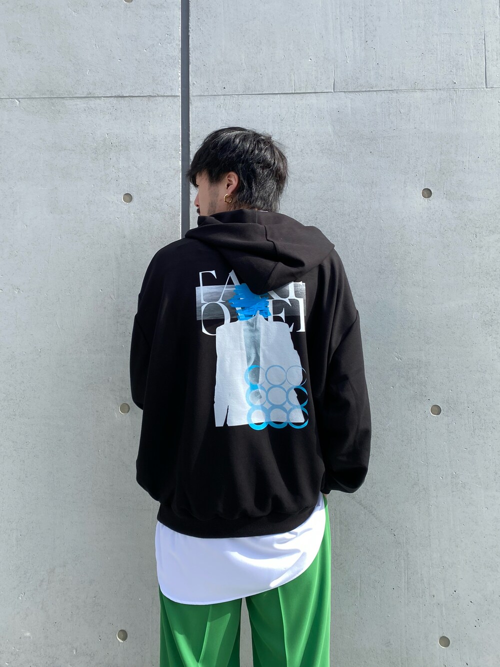 ブラック系のパーカー、ホワイト系のシャツ/ブラウス、グリーン系のスラックスを着用したメンズの冬コーディネートの3枚目の写真