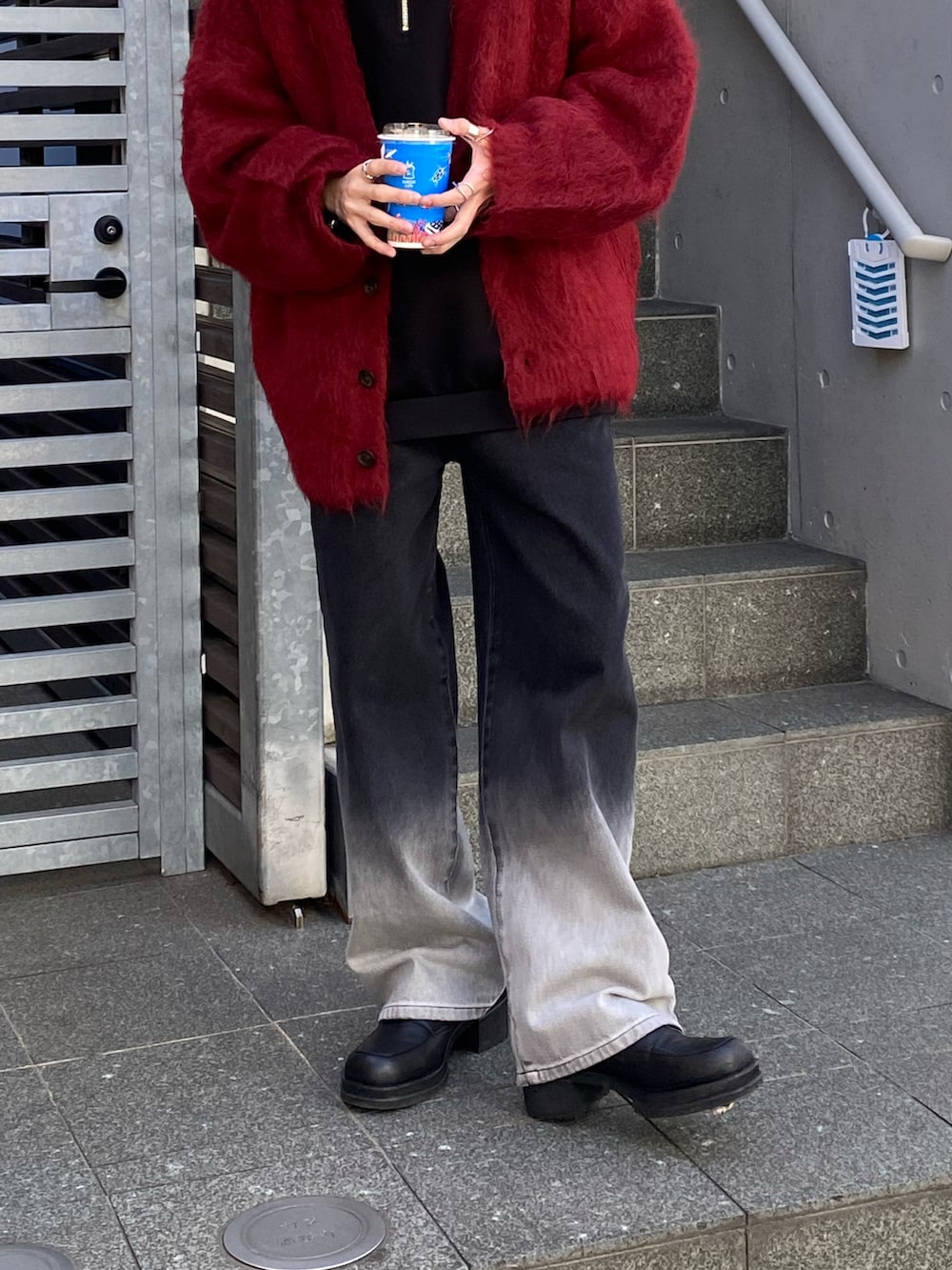 レッド系のカーディガン/ボレロ、ブラック系のデニムパンツ、ブラック系のTシャツ/カットソーを着用したメンズの秋コーディネートの4枚目の写真