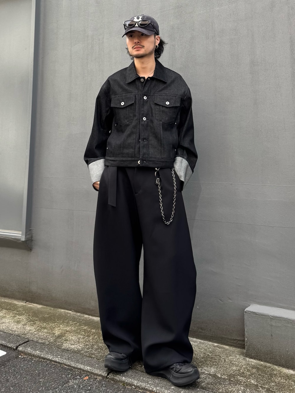 ブラック系のデニムジャケット、ブラック系のスラックス、ブラック系のウォレットチェーンを着用したメンズの春コーディネートの3枚目の写真