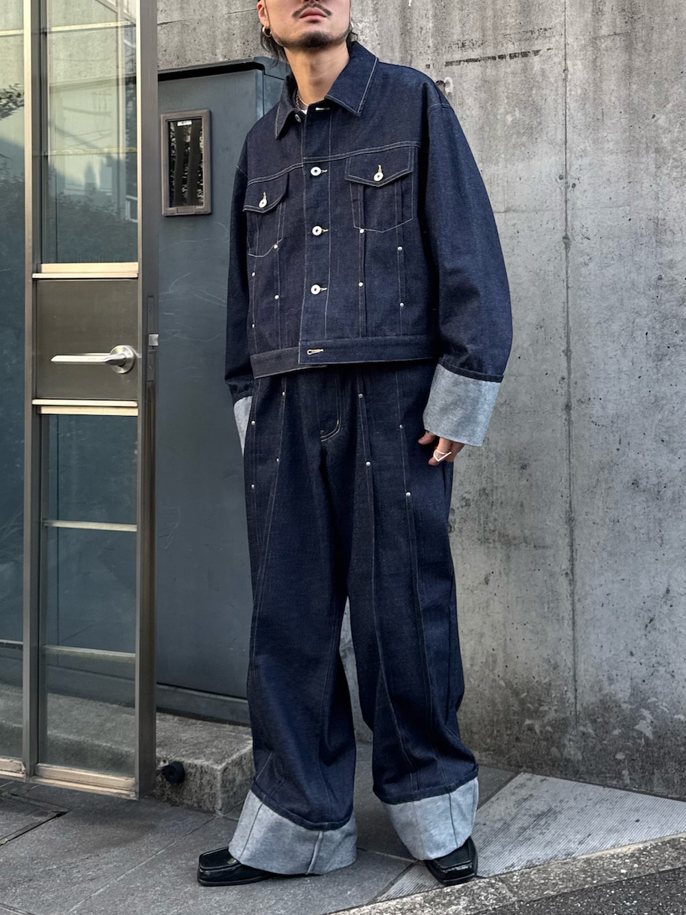 ブルー系のデニムジャケット、ブルー系のデニムパンツ、ブラック系のローファーを着用したメンズの冬コーディネートの2枚目の写真