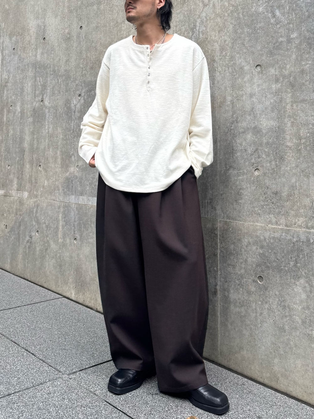 ホワイト系のTシャツ/カットソー、ブラウン系のスラックス、ブラック系のローファーを着用したメンズの秋コーディネートの2枚目の写真