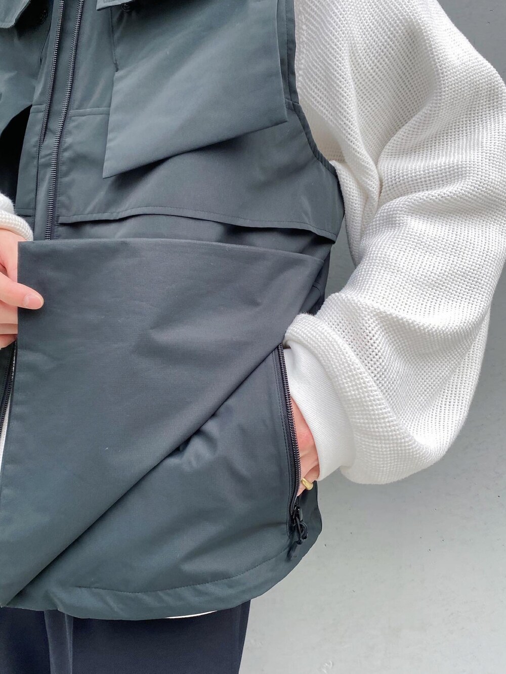 ブラック系のベスト、ブラック系のスラックス、ブラック系のブーツを着用したメンズの冬コーディネートの5枚目の写真