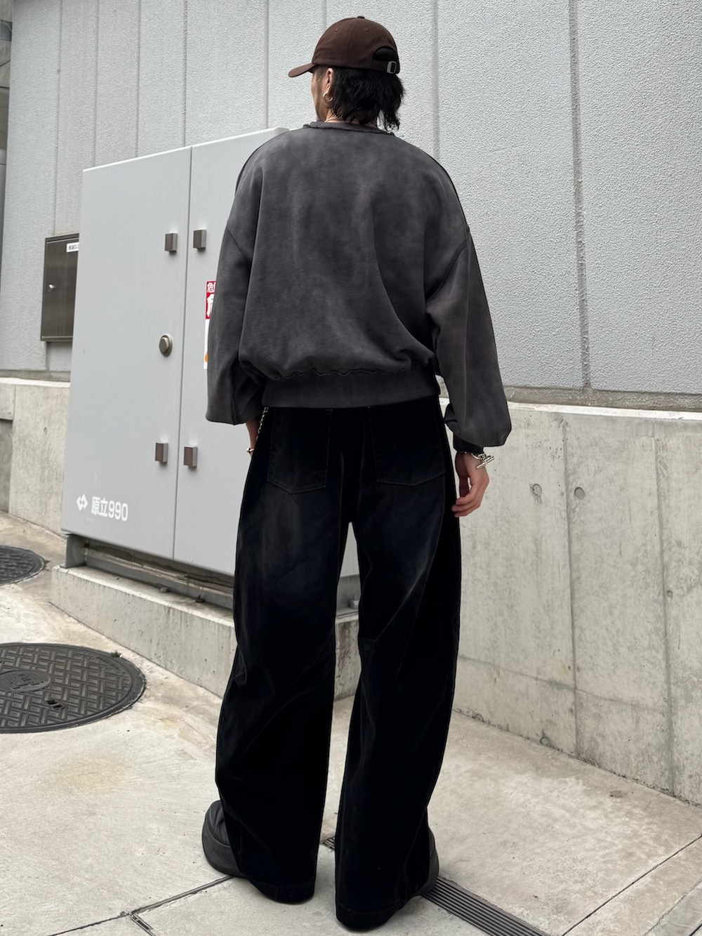 ブラック系のスウェット、ブラック系のデニムパンツ、シルバー系のウォレットチェーンを着用したメンズの春コーディネートの4枚目の写真