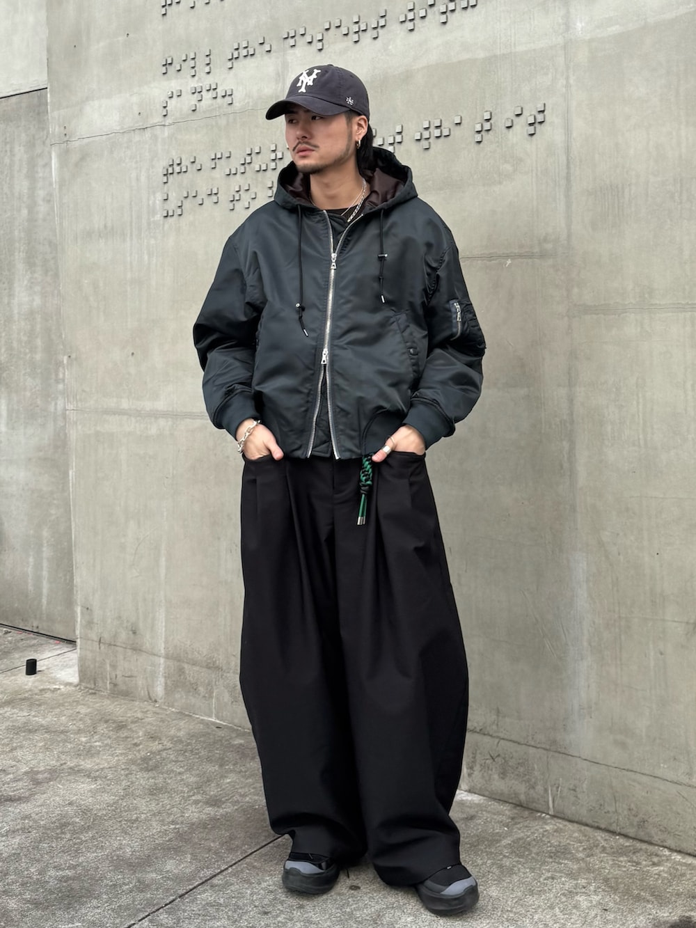 グリーン系のブルゾン、ブラック系のその他パンツ、ブラック系のキーホルダーを着用したメンズの冬コーディネートの3枚目の写真