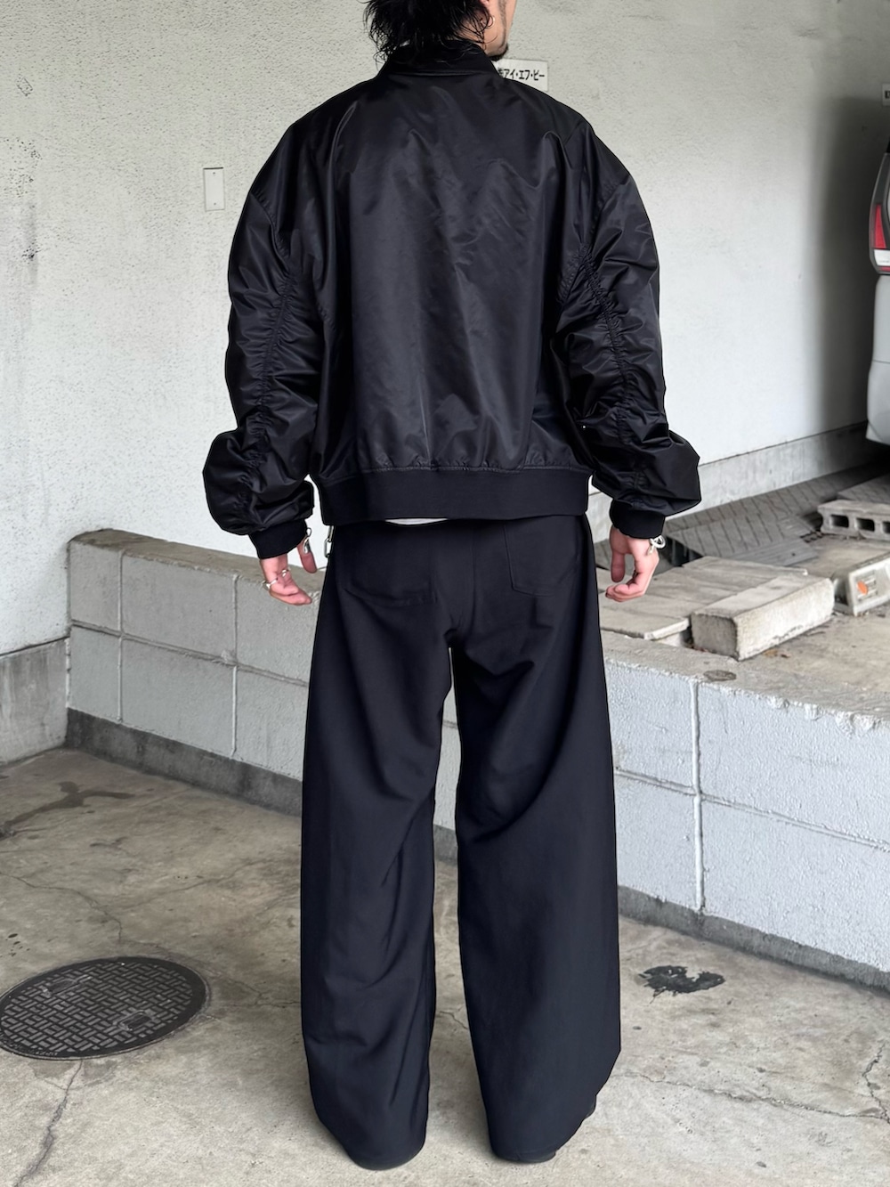 ブラック系のMA-1、ブラック系のスラックスを着用したメンズの秋コーディネートの4枚目の写真