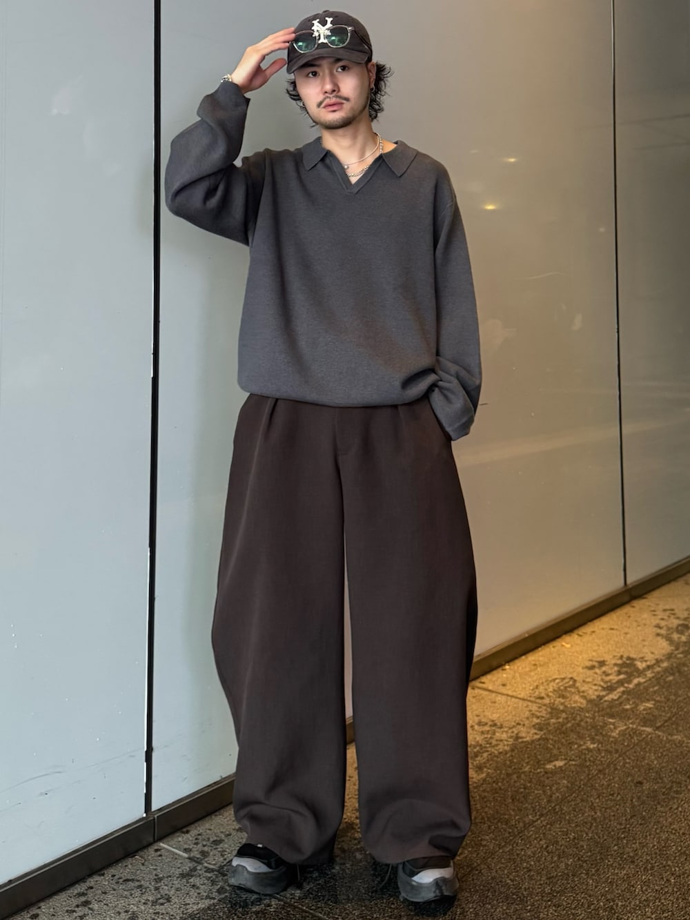 グレー系のニット/セーター、グレー系のスラックスを着用したメンズの秋コーディネートの2枚目の写真