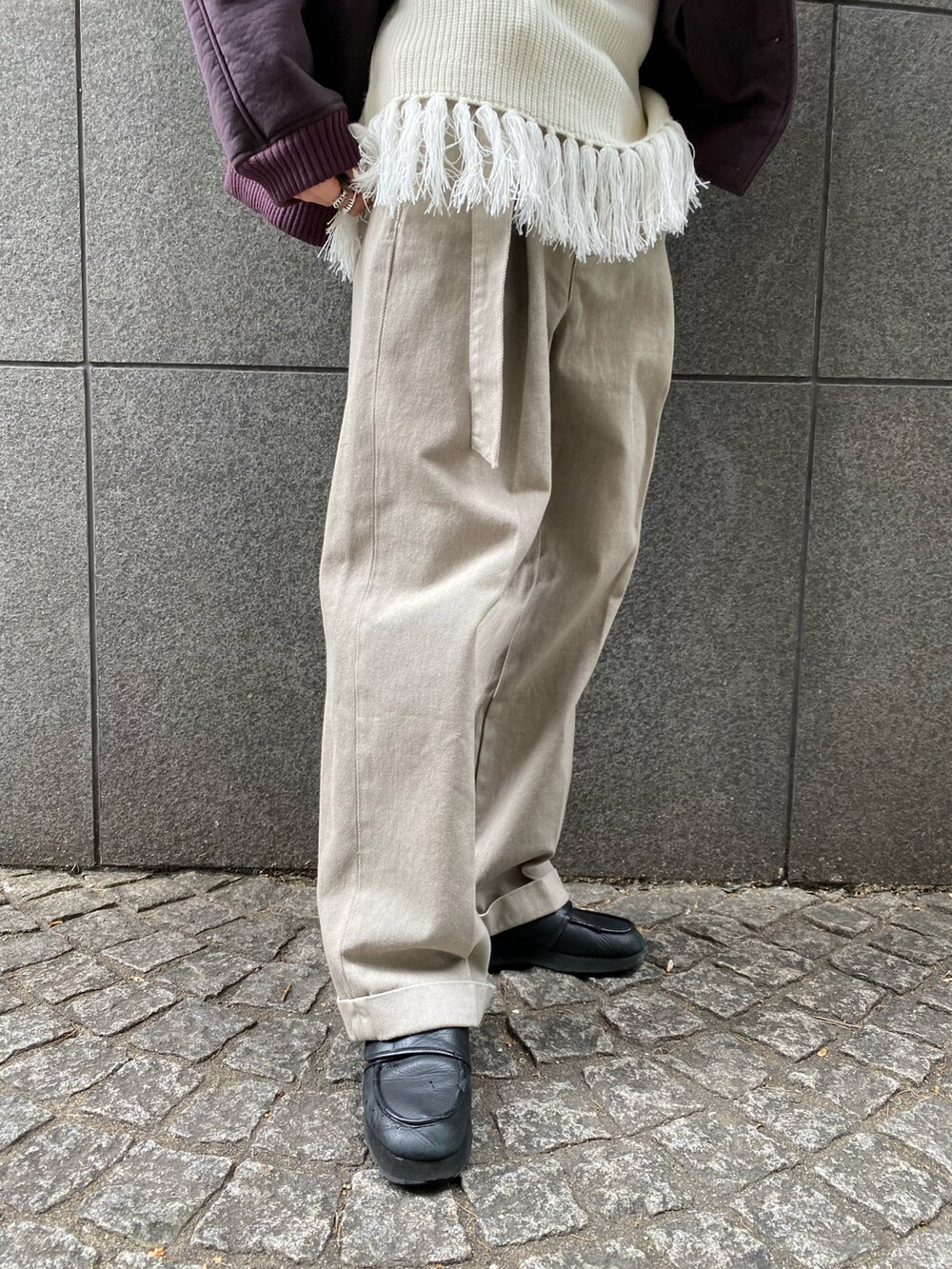 パープル系のブルゾン、ホワイト系のニット/セーター、ベージュ系のデニムパンツを着用したメンズの秋コーディネートの4枚目の写真