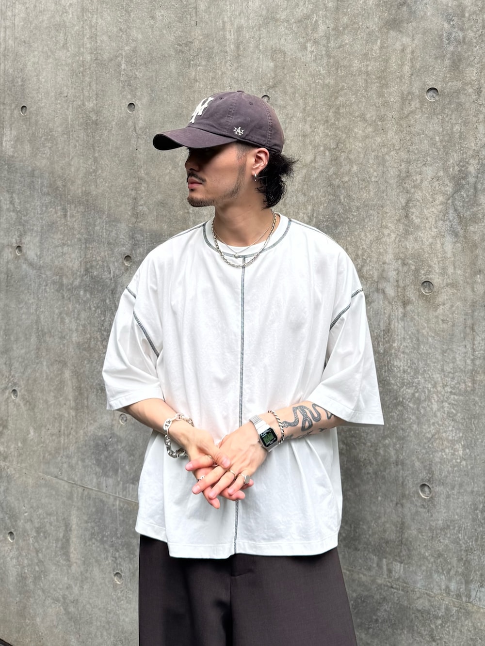 ホワイト系のTシャツ/カットソー、ブラウン系のスラックスを着用したメンズの夏コーディネートの3枚目の写真