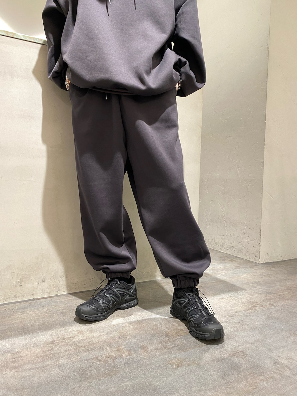 グレー系のパーカー、グレー系のスウェットパンツ、ブラック系のその他シューズを着用したメンズの秋コーディネートの5枚目の写真