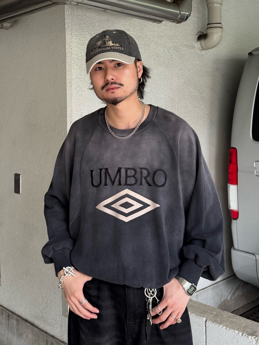 グレー系のスウェット、ブラック系のデニムパンツを着用したメンズの春コーディネートの3枚目の写真