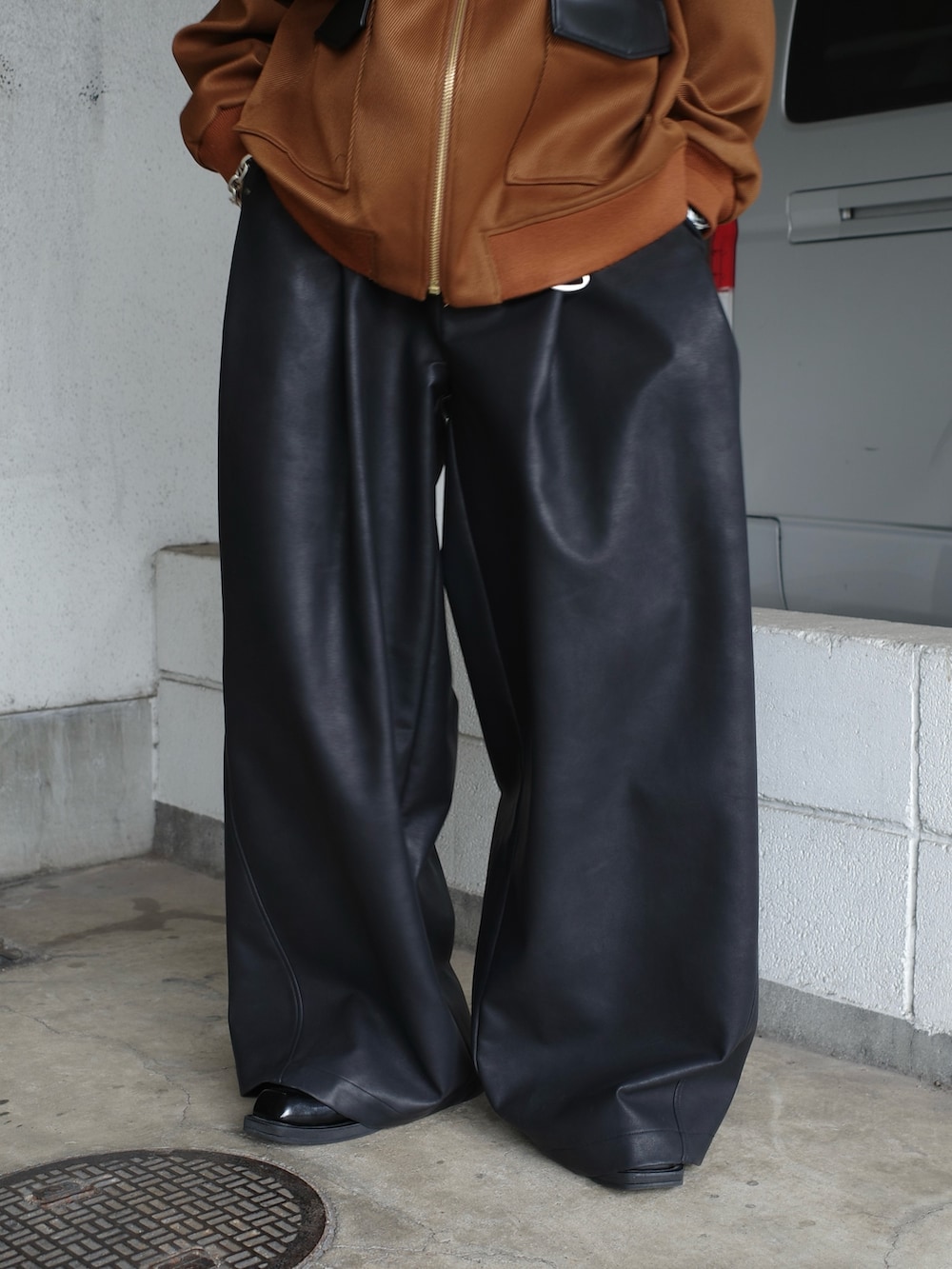 ベージュ系のブルゾン、ブラック系のその他パンツを着用したメンズの秋コーディネートの6枚目の写真