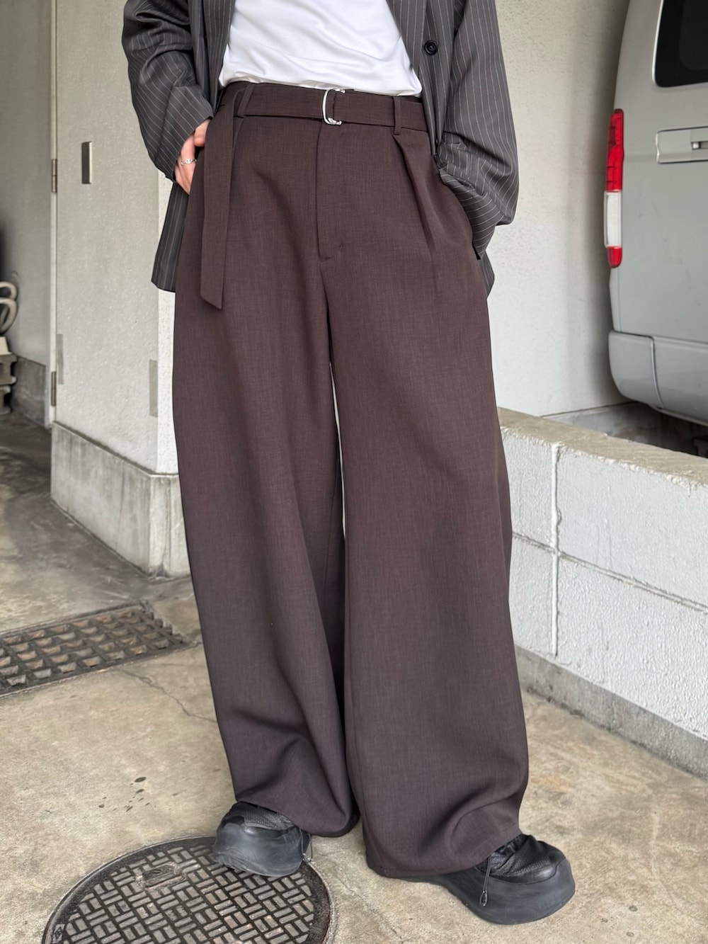 グレー系のテーラードジャケット、グレー系のスラックス、ホワイト系のTシャツ/カットソーを着用したメンズの春コーディネートの8枚目の写真