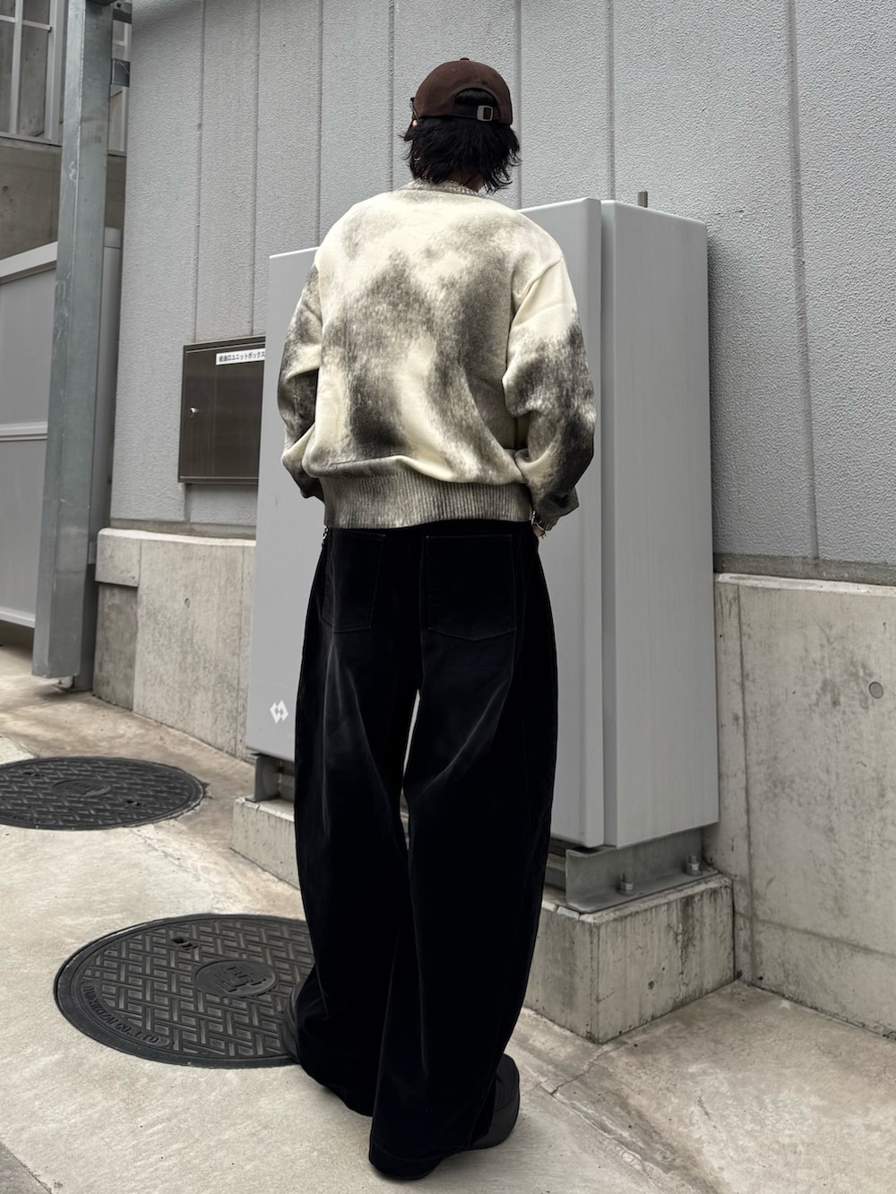 ホワイト系のニット/セーター、ブラック系のデニムパンツ、シルバー系のウォレットチェーンを着用したメンズの春コーディネートの3枚目の写真