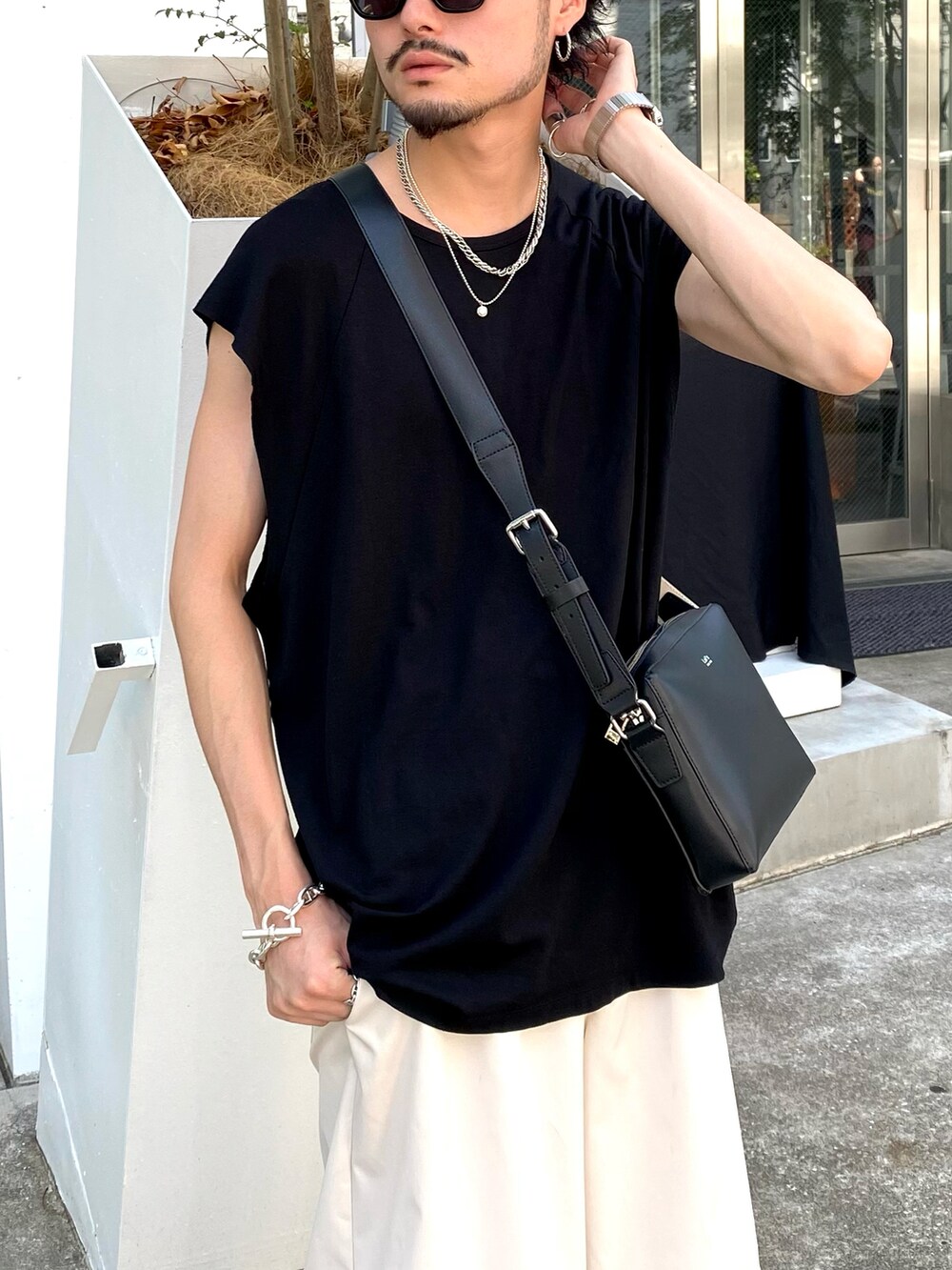 ブラック系のTシャツ/カットソー、ホワイト系のその他パンツ、ブラック系のショルダーバッグを着用したメンズの夏コーディネートの4枚目の写真
