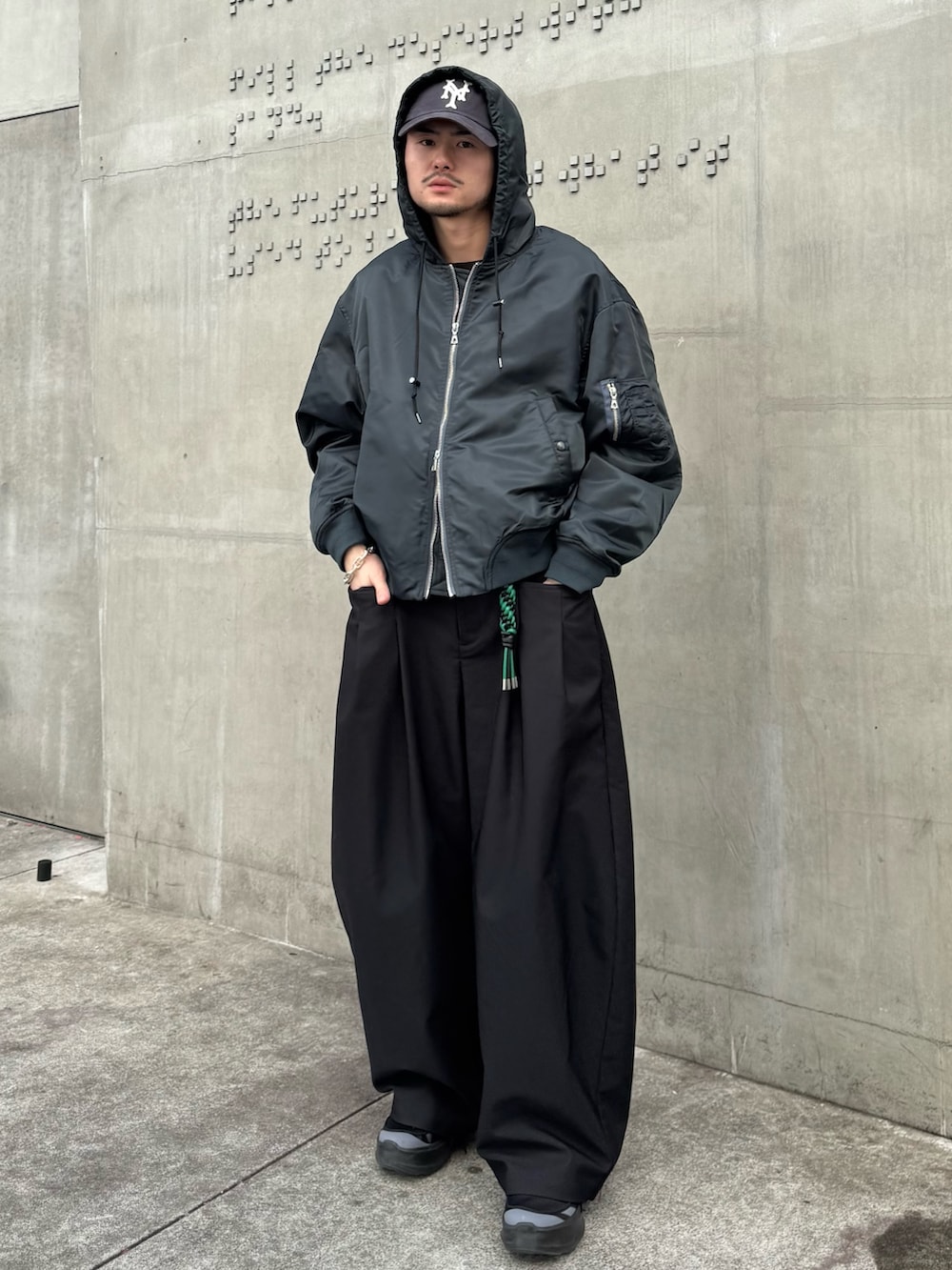 グリーン系のブルゾン、ブラック系のその他パンツ、ブラック系のキーホルダーを着用したメンズの冬コーディネートの2枚目の写真