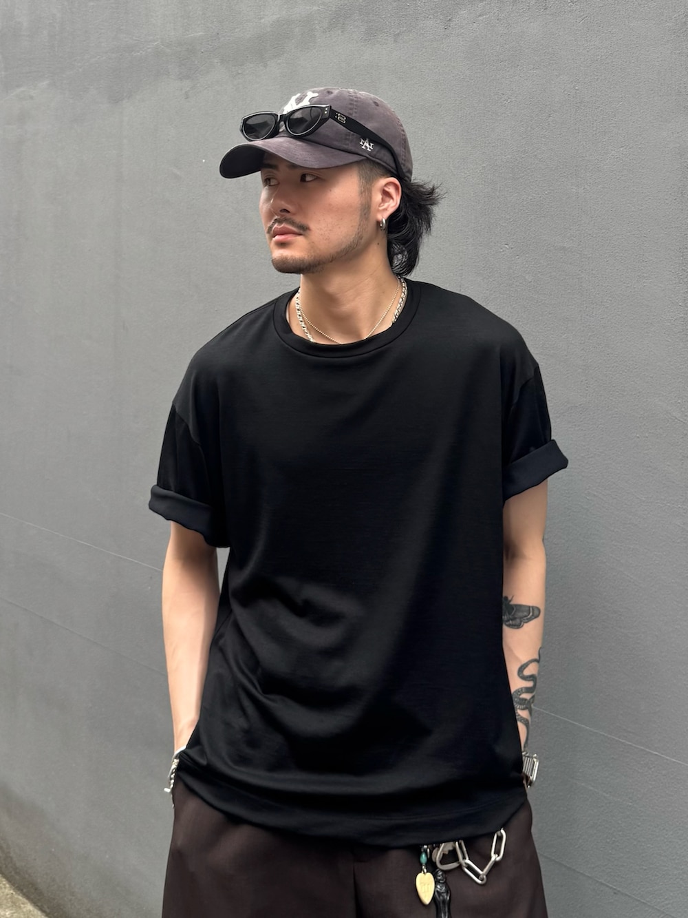 ブラック系のTシャツ/カットソー、グレー系のスラックスを着用したメンズの夏コーディネートの5枚目の写真