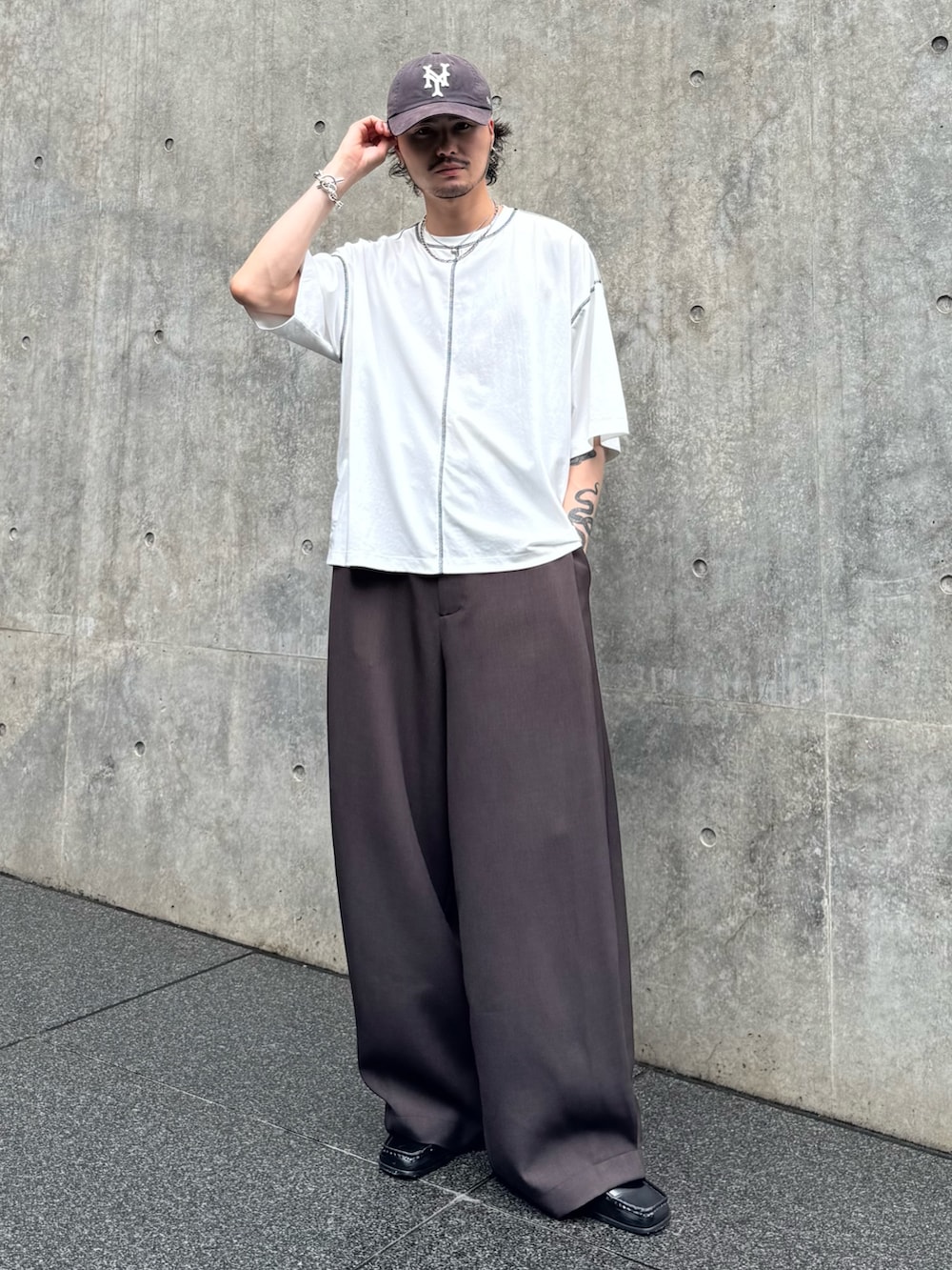 ホワイト系のTシャツ/カットソー、ブラウン系のスラックスを着用したメンズの夏コーディネートの2枚目の写真