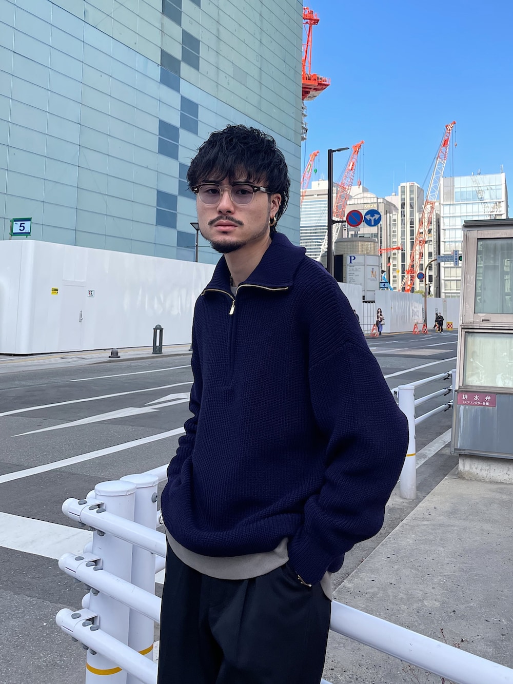 ブルー系のニット/セーター、ブラック系のスラックスを着用したメンズの冬コーディネートの3枚目の写真