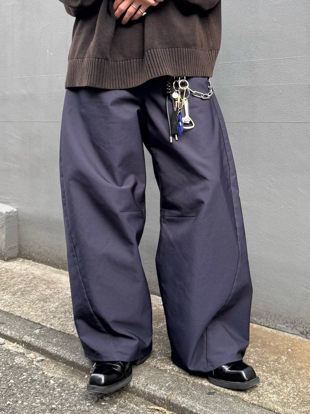 ブラック系のニット/セーター、ブルー系のスラックス、ブルー系のキャップを着用したメンズの秋コーディネートの6枚目の写真