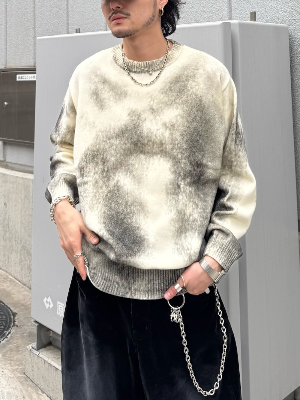 ホワイト系のニット/セーター、ブラック系のデニムパンツ、シルバー系のウォレットチェーンを着用したメンズの春コーディネートの6枚目の写真